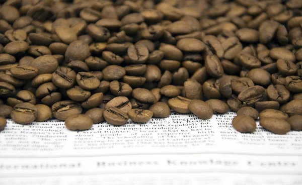 Kahve fincanı ve kahve çekirdekleri ahşap masada.