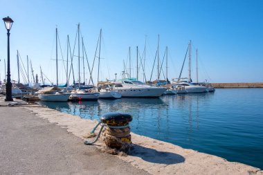 Limandaki otoparkta mavi gökyüzüne karşı yelken açan yatlar.