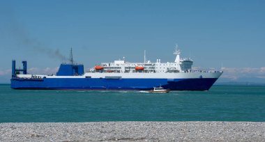 Mavi ve beyaz yolcu gemisi kıyıya yaklaşıyor.