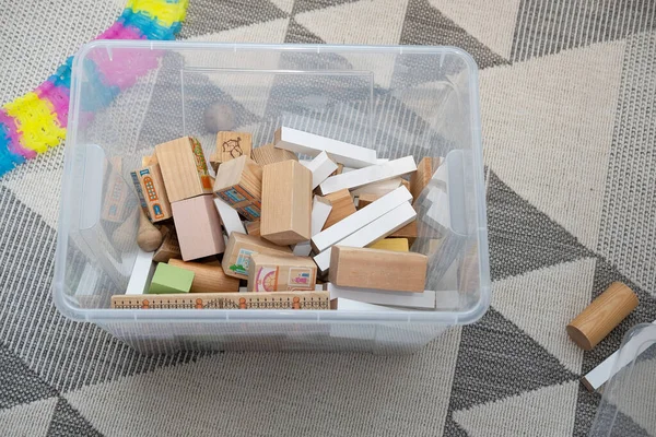 Tahta çocuk tasarımcısının parçalarıyla dolu plastik bir kutu.
