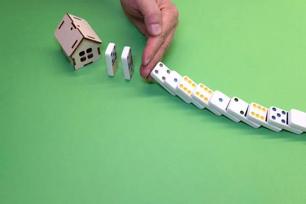 hand does not allow dominoes to fall on the house