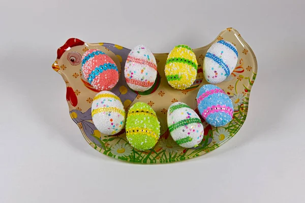 Huevos de Pascua en un plato en forma de pollo sobre un fondo blanco — Foto de Stock