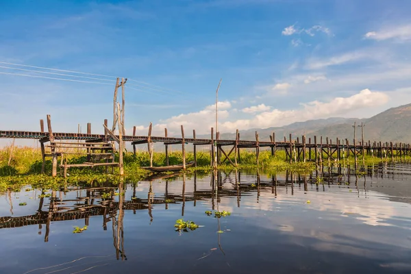Inle Lake, Myanmar. Wooden pillar bridge of Mine Thauk village is connection between land part houses and floating gardens on the water of the village.
