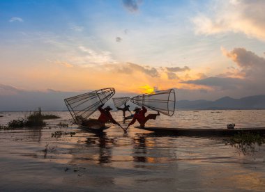 Inle Gölü, Myanmar. Intha Shan devletin etnik grup poz bambu tekne turist için geleneksel giyimli balıkçılar.