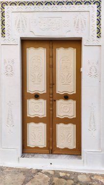 Geleneksel eski boyanmış kapı tarihi bir bölgede ya da Medine, Tunus 'ta. Müslüman mimarisinin renkli desenli görüntüsü.