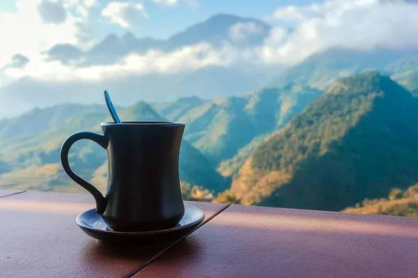 Bulutlardaki dağların arka planında bir fincan üzerinde koyu bir fincan. Sapa, Lao Cai Eyaleti, Kuzeybatı Vietnam
