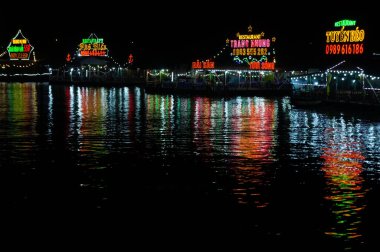 Cat Ba Adası, Vietnam 17 Ekim 2019. Geceleri deniz kenarındaki restoranlar. Siyah sudaki çiçek lekesi renk yansıması