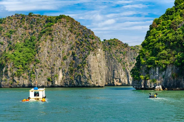 Halong Körfezi Adaları. Turistik eğlence, muhteşem kireçtaşı mağaraları doğal mağara oluşumları. Karst 'ın denizdeki toprakları, dünya mirası. Gölün güzel gök mavisi suyu. İki tekne açıldı.