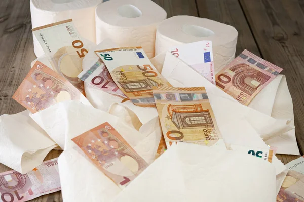 Çarşaflar ve tuvalet kağıdı rulosu, euro parası, ahşap arka planda. konsept
