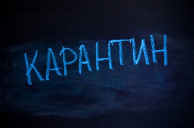 Rus harflerindeki yazı: karantina. Tebeşir tahtasındaki yazı. Mavi tebeşir