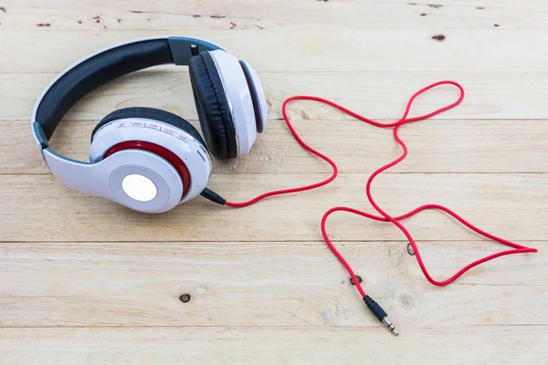 White Headphones on wood desk.