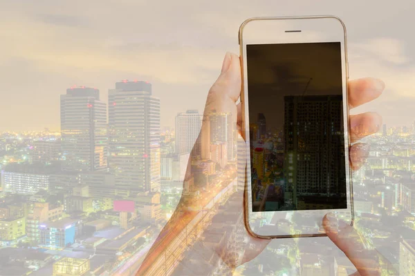 Doble exposición de la mujer usando su teléfono inteligente y skyline de la ciudad —  Fotos de Stock