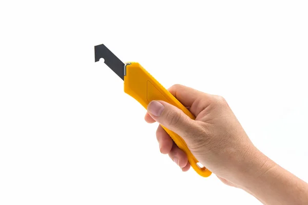 Primeros planos de mano que sostiene el cuchillo de corte laminado plástico amarillo . —  Fotos de Stock