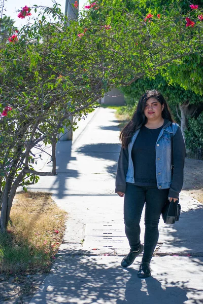 chubby woman with latin or hindu appearance walking in the park