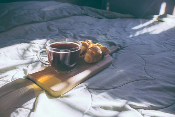 Romantikus reggeli kávéval és croissant felszolgált ágyban az asztalon — Stock Fotó
