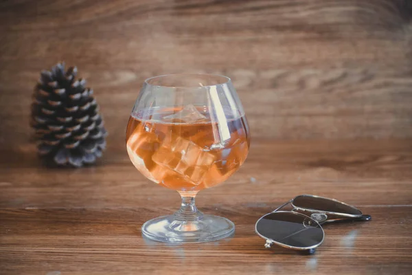 Composición empresarial con vidrio con delicioso whisky junto a lentes aviador. sobre tablas de roble — Foto de Stock