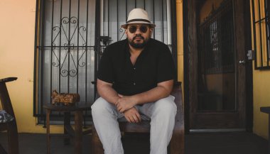 Fötr şapkalı, havacı gözlüğü takan tombul, yakışıklı Meksikalı adam.