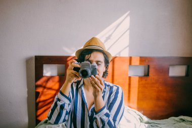 Eski kamera kullanan hippi görünümlü Latin bir kadın.