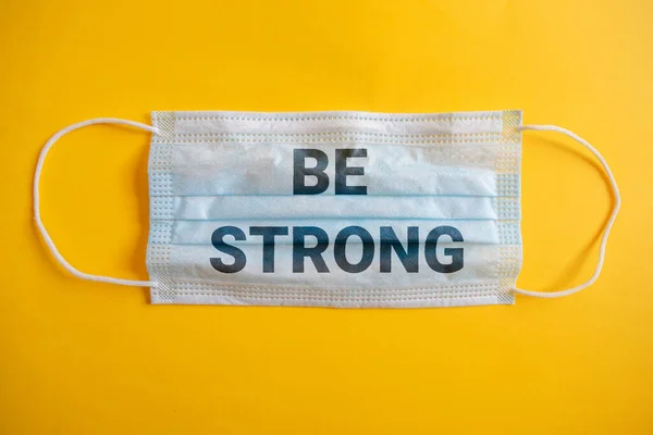 mouth cover with the phrase be strong. with yellow isolated background