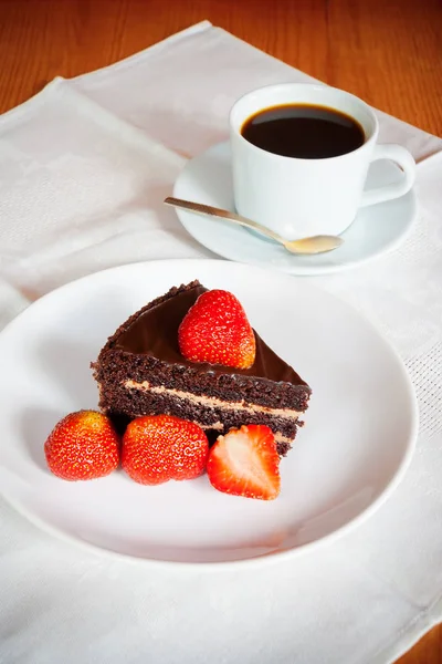 新鮮なイチゴと一杯のコーヒーとチョコレート ケーキ。ケーキの選択と集中 — ストック写真