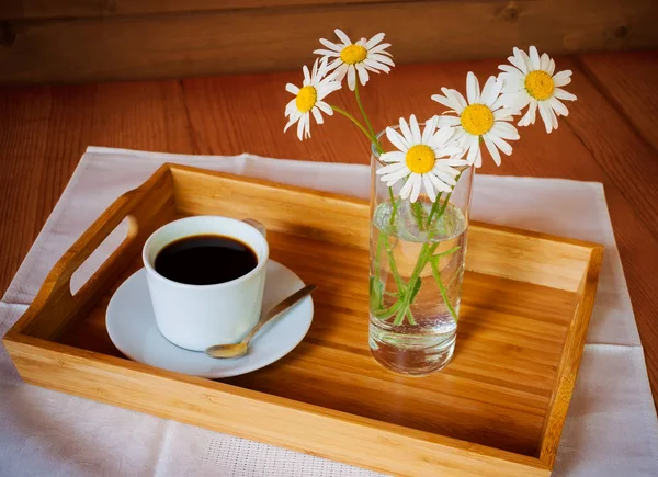 Caffè e camomille sul tavolo di legno. Focus selettivo — Foto Stock