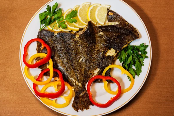 Ahşap arka plan üzerinde sebze ile pişmiş pisi balığı