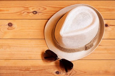 Şapka ve güneş gözlüğü ahşap arka plan üzerinde. Gevşeme ya da tatil kavramı