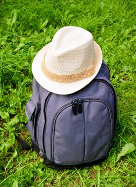 Gri beyaz şapka ile sırt çantası çimenlerin üzerinde
