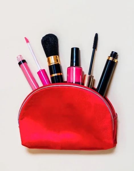 Sac de maquillage avec produits cosmétiques débordant sur fond beige — Photo