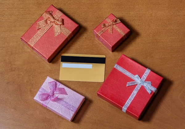 Tarjetas de crédito y cajas de regalo sobre fondo de madera — Foto de Stock