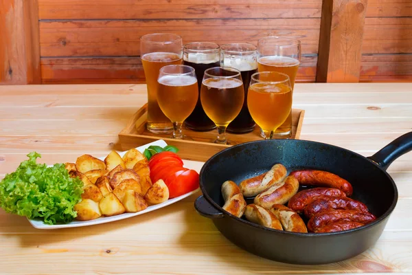 Bira, kavrulmuş patates ve ızgara sosis. Seçici odak