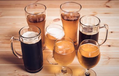 Bira gözlük ve bira bardağı ahşap masa üzerinde. Seçici odak. Vintage tarzı