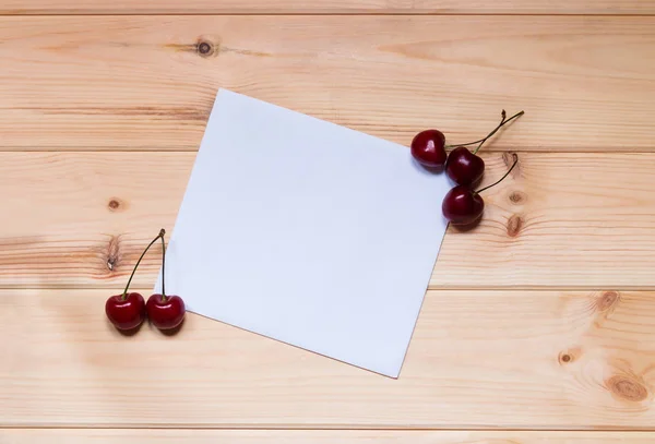 Card for notes with cherries on wooden background. — Stock Photo, Image
