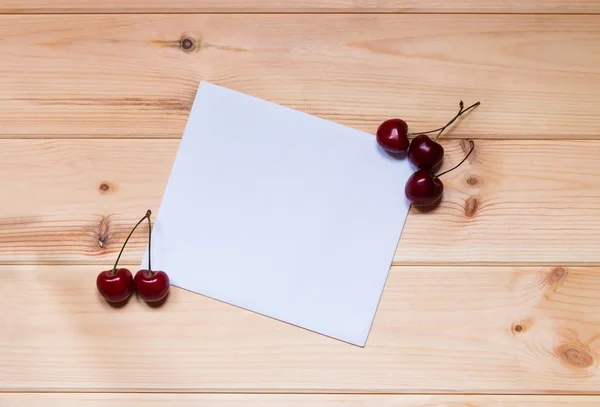 Tarjeta para notas con cerezas sobre fondo de madera . —  Fotos de Stock