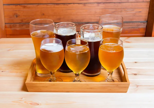 Bicchieri di birra e tazze di birra sul tavolo di legno. Focus selettivo — Foto Stock