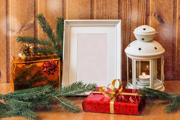 Witte foto frame, lantaarn en kerst cadeaus op houten tafel. — Stockfoto