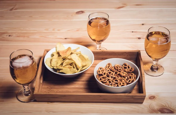 Tres vasos de cerveza y bocadillos de cerveza en la mesa de madera. Estilo vintage — Foto de Stock