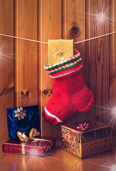 Christmas stocking en geschenken tegen een houten muur. Vintage stijl — Stockfoto