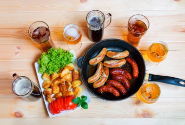 Bira, kavrulmuş patates ve ızgara sosis