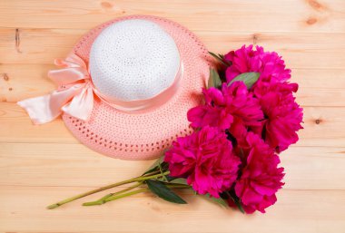 Peonies ve şapka ahşap yüzeyde oluşan grup. Üstten Görünüm