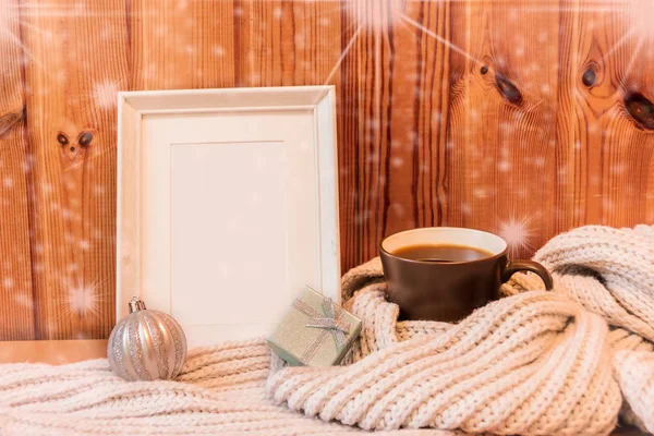 Marco de madera blanco, taza envuelta en bufanda de lana gris, bola de Navidad y regalo —  Fotos de Stock