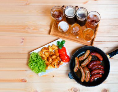 Bira, kavrulmuş patates ve ızgara sosis. Üstten Görünüm