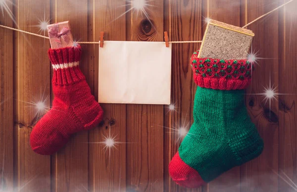 Meias de Natal e cartão de saudação na parede de madeira. Estilo vintage — Fotografia de Stock