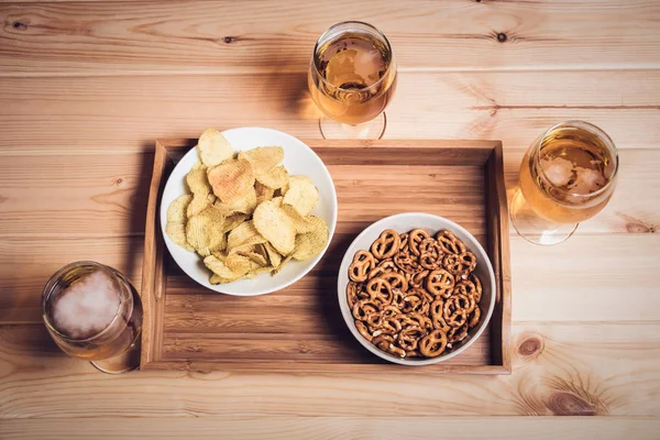 Vasos de cerveza y aperitivos de cerveza en la mesa de madera. Estilo vintage — Foto de Stock