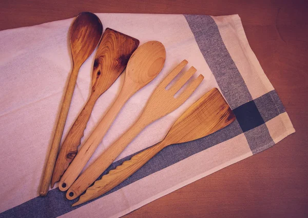 Houten keukengerei en keuken handdoek op houten tafel — Stockfoto