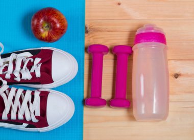Spor ayakkabı ve apple yoga mat, şişe su ve halter