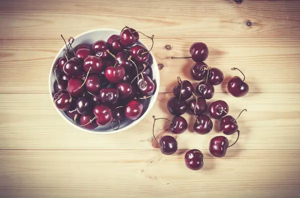 Fresh ripe cherries berries in white bowl on wooden background. — Stock Photo, Image