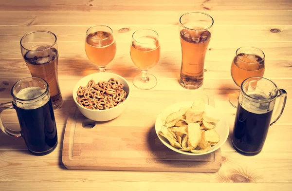 Tazas de cerveza, vasos y aperitivos de cerveza en la mesa de madera. Enfoque selectivo . — Foto de Stock