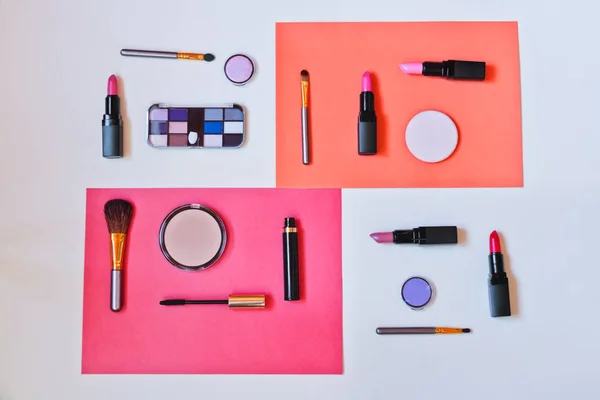 Trucchi cosmetici e pennelli su sfondo di carta colorato — Foto Stock