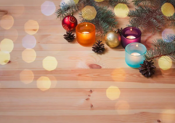 Vuurtakken, kaarsen in glazen kandelaars, dennenappels en kerstballen. — Stockfoto